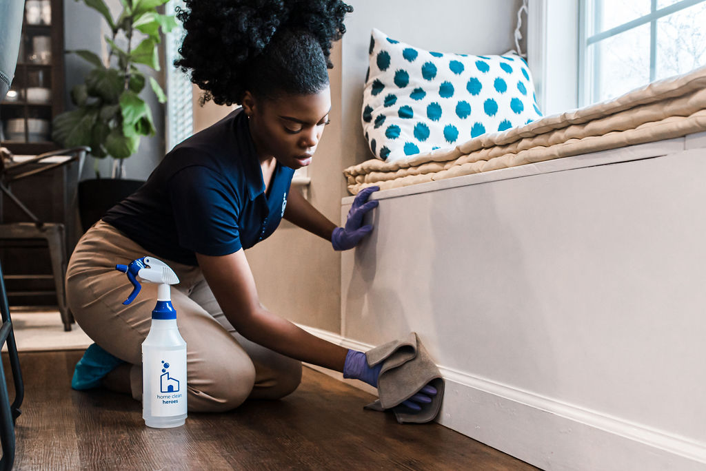 A black cleaner wiping a furniture